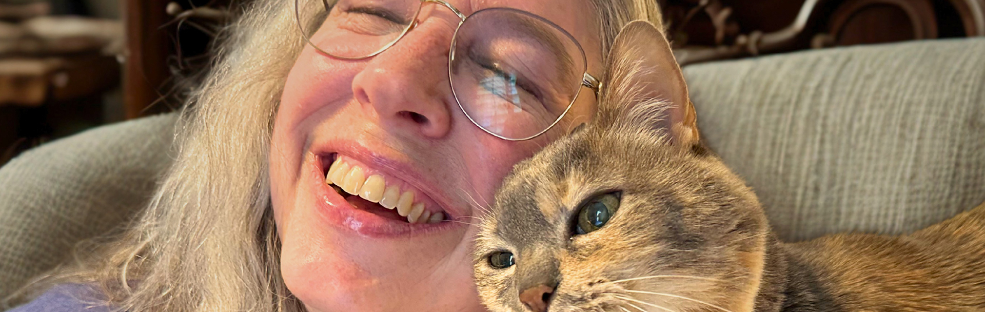 Marci smiling with her cat Bobbi, reflecting Love in everyday life