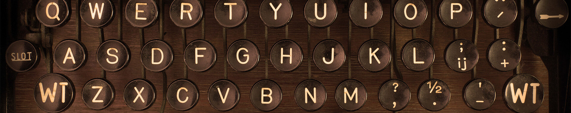 An antique typewriter's keys are featured in the image, showing a QWERTY layout with additional symbols and numbers, evoking a sense of nostalgia and vintage communication.